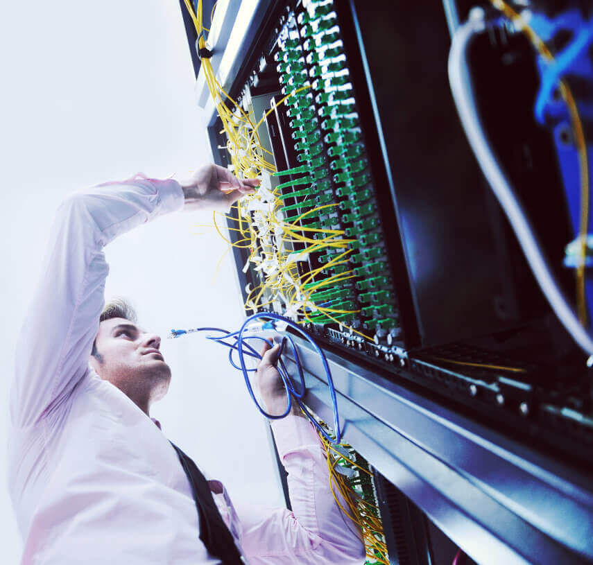 Man connecting wires into network patch panel